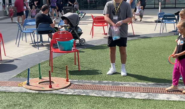 Family‑friendly event setup with children and adults participating in outdoor games at a community gathering